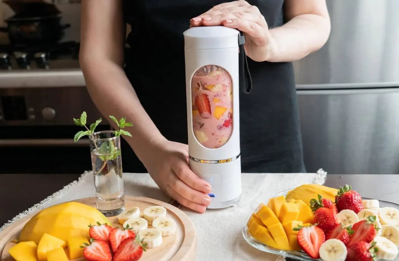 Femme préparant un smoothie avec un mixeur portable rechargeable
